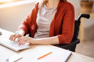 businesswoman-in-wheelchair-at-the-desk-in-her-PX8Z9SG-min-scaled